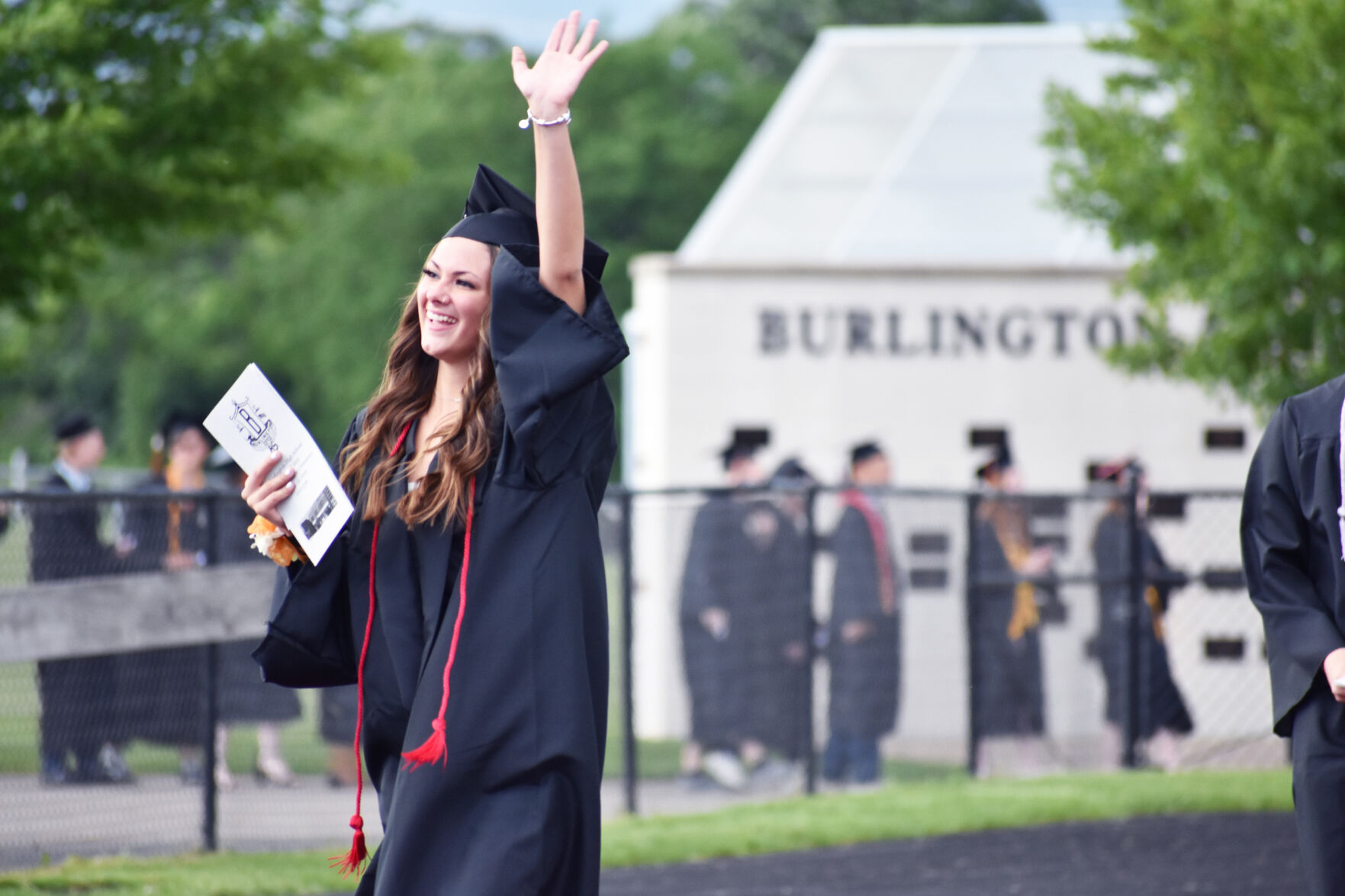Burlington High School graduate Mackenzie Perez waves during commencement